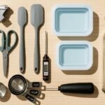 Flat lay of affordable Amazon kitchen tools under $30 including garlic press, spatulas, and herb scissors – 2025 picks, Budget kitchen gadgets from Amazon used in meal prep and cooking – top tools for 2025, Affordable and practical kitchen tools from Amazon featured in 2025 best picks list.
